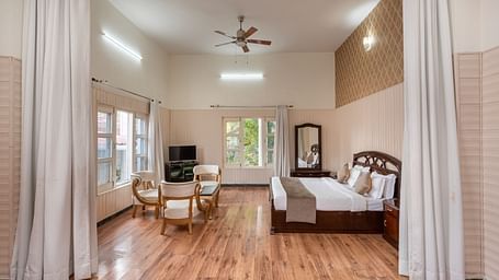 Luxurious suite featuring a bedroom and a living area at DLS Tehri Club Resort.